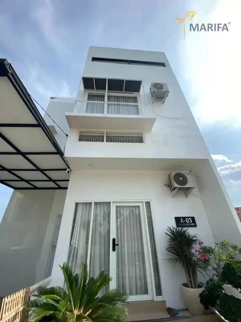 tukang bangunan sedang mengukur dinding rumah untuk estimasi biaya renovasi